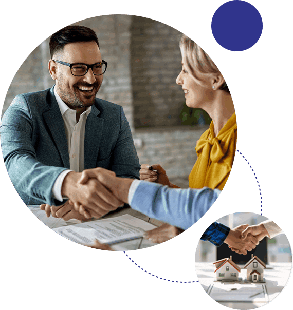 Two professionals shaking hands across a desk in a meeting.
